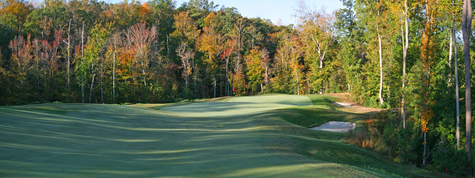 Fall foliage framing a green at Colonial Heritage Club golf course in Williamsburg, VA